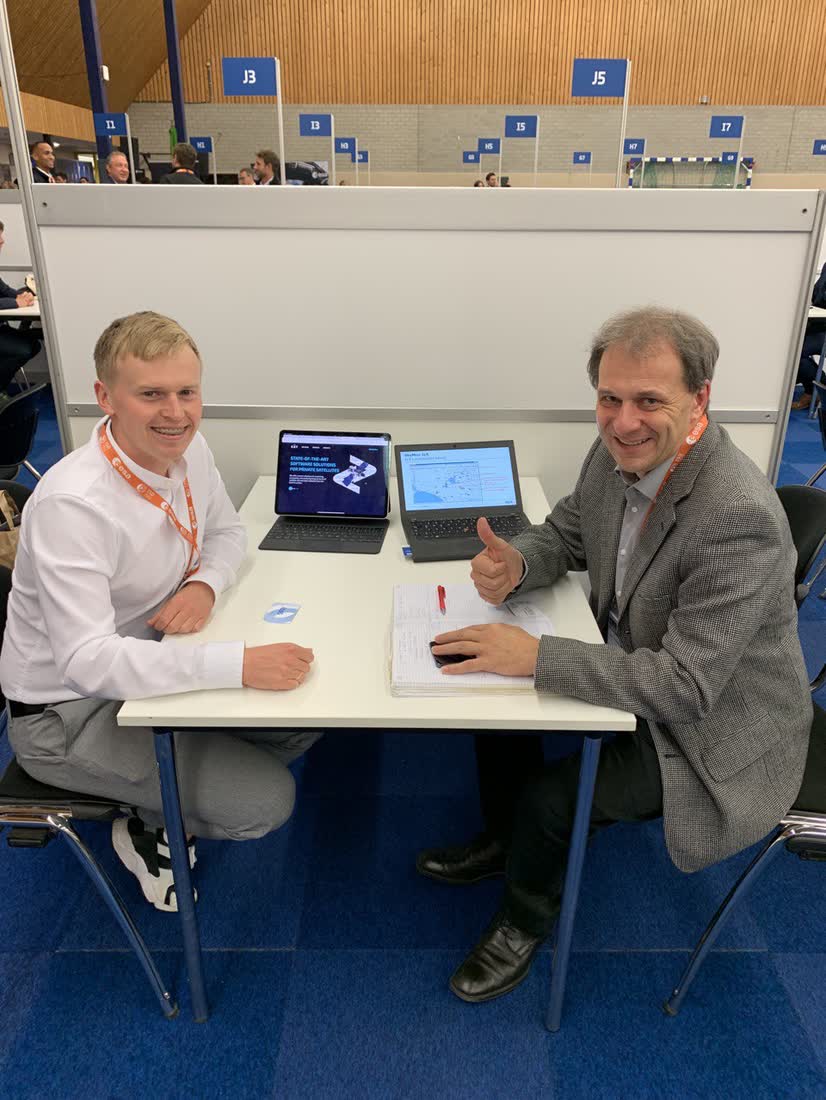 Fluvius engineers in a working meeting at the European Space Agency stand in the Netherlands, laptops open across the table