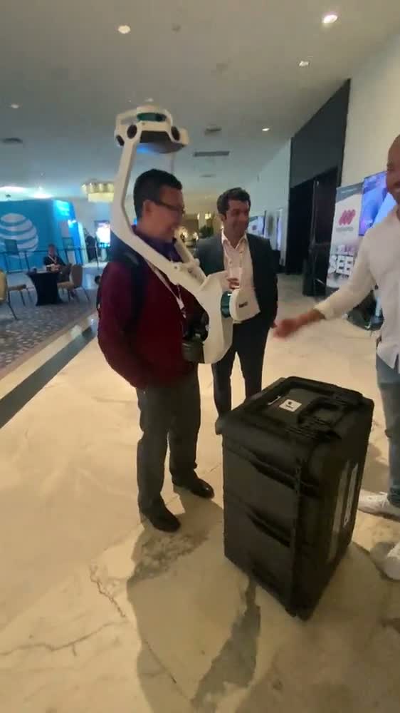 A Fluvius engineer wearing a backpack-mounted 3-D capture rig on the show floor at Immerse Global Summit